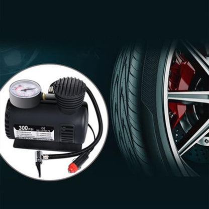 Car tire inflator with pressure gauge next to a car tire on a dark background